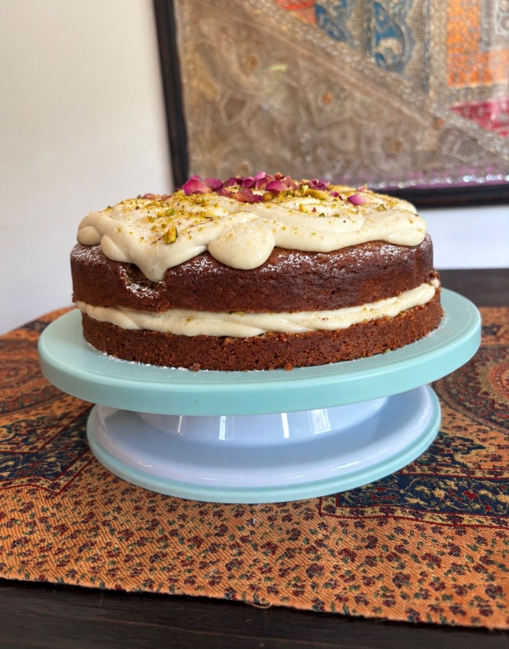 A pistachio and cardamom layer cake with mascarpone icing, topped with chopped pistachios